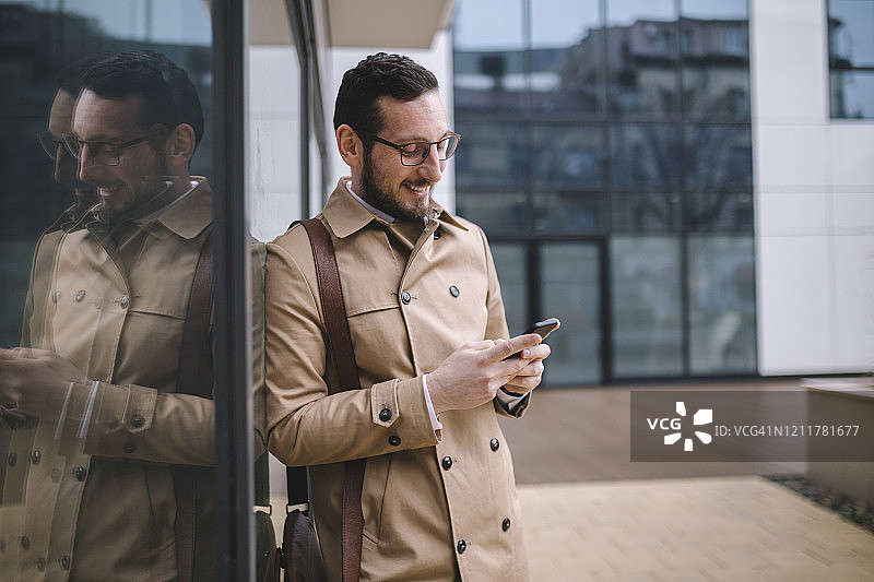 男人走在去办公室的街上使用手机图片素材
