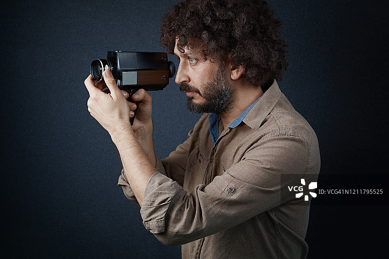 年轻的电影摄影师用老式胶片相机拍摄图片素材