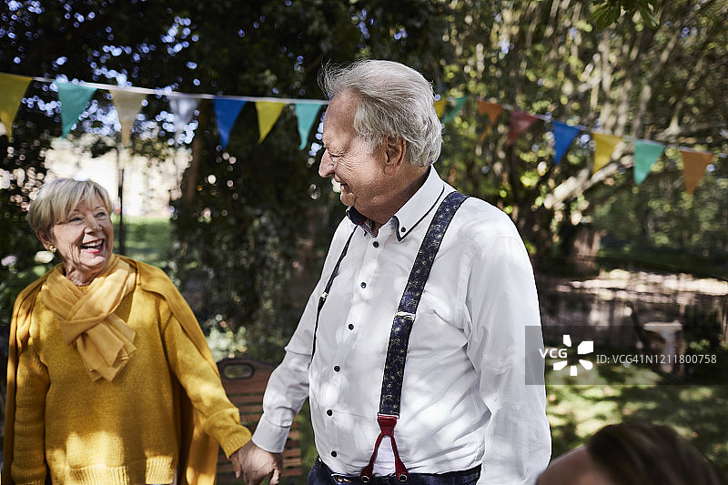 快乐的老年夫妇举办花园派对图片素材