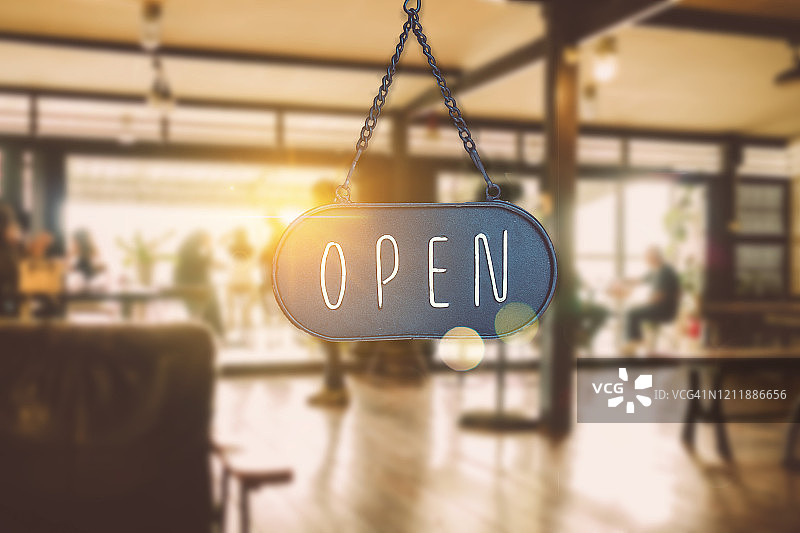 咖啡馆或餐厅入口处挂着的“营业中”标牌，复古色调图片素材