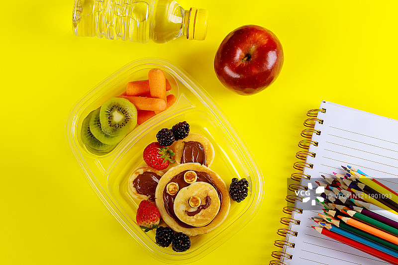 含薄煎饼、榛子酱、水果和蔬菜的健康午餐盒图片素材