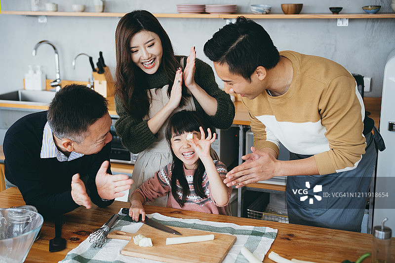 三代同堂：小女孩在厨房里一起快乐地准备食物图片素材
