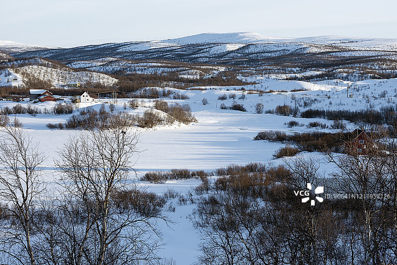 挪威考托凯诺地区阿夫济附近的萨米人定居点和冰冻的河流图片素材
