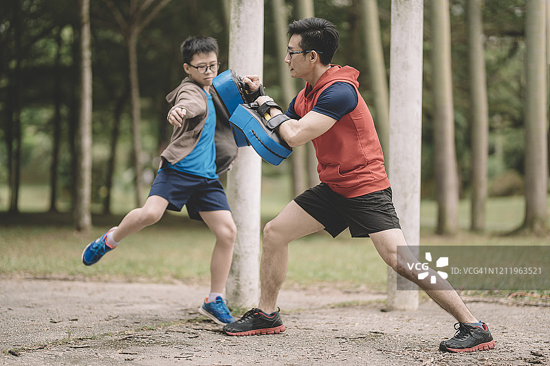 中国父亲在公园训练儿子图片素材