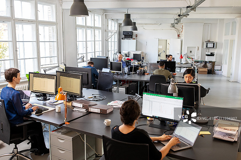 在开放式办公室工作的商务人士图片素材