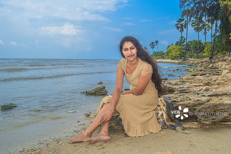 女人坐在贾夫纳马塔加尔海滩图片素材