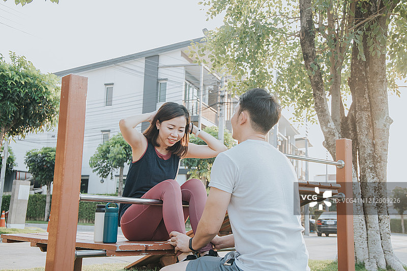快乐的年轻亚洲女人在户外做仰卧起坐练习腹部图片素材