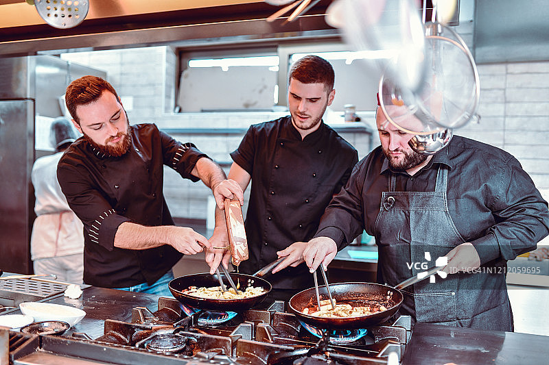 三位厨师一起制作特色菜图片素材