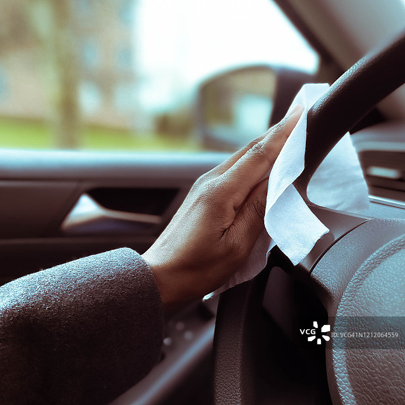 女人用消毒湿巾清洁方向盘图片素材