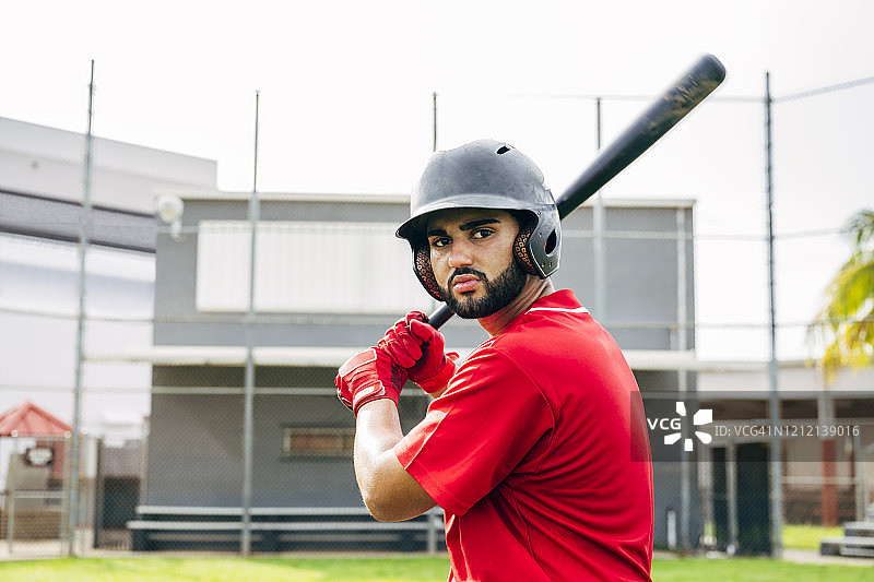 户外击球姿势的西班牙裔胡须棒球运动员图片素材