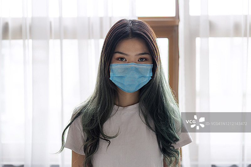居家戴口罩的中国年轻女性图片素材