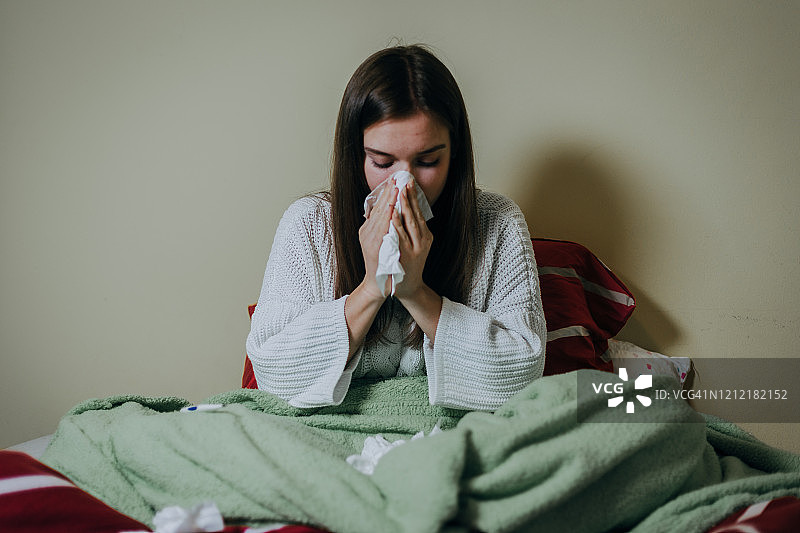 盖着毯子卧床不起的女人图片素材