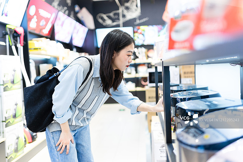 亚洲女性在超市购买电饭煲图片素材