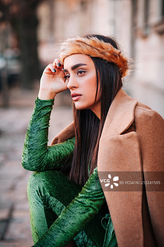 身穿绿色毛绒服装的时尚女人摆姿势图片素材