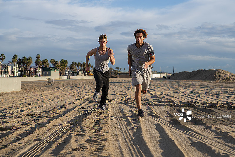 在海滩慢跑的两个年轻朋友图片素材