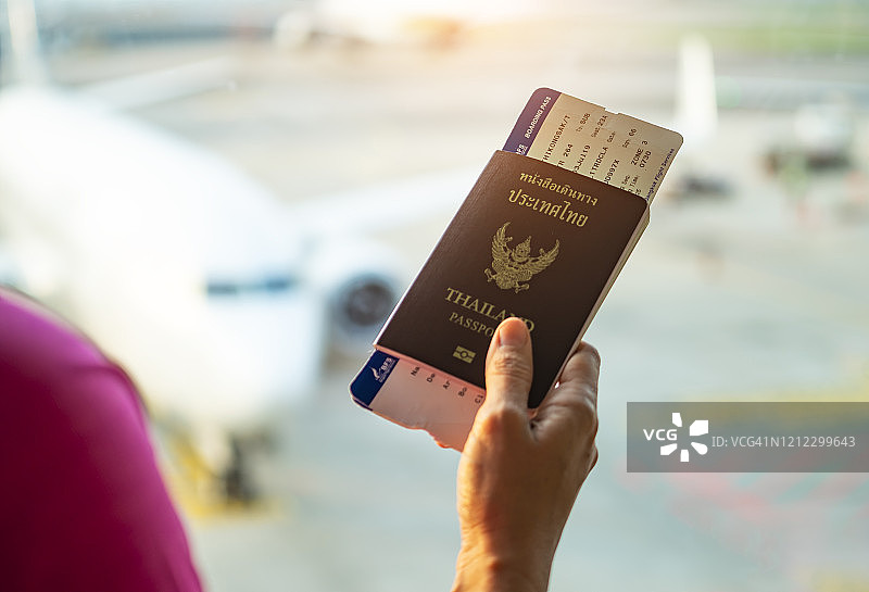 手持泰国护照，机场背景图片素材