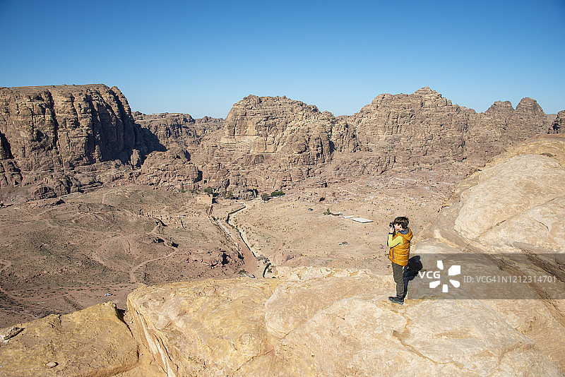 男孩在约旦佩特拉山顶拍照图片素材