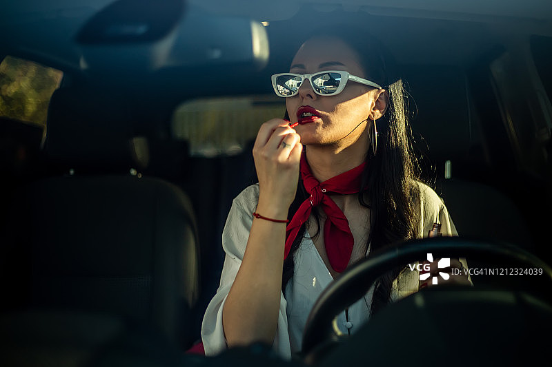 女人在车里涂口红图片素材