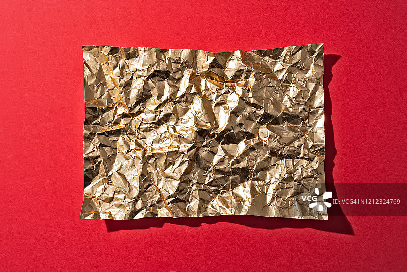 红色背景上的褶皱金纸图片素材