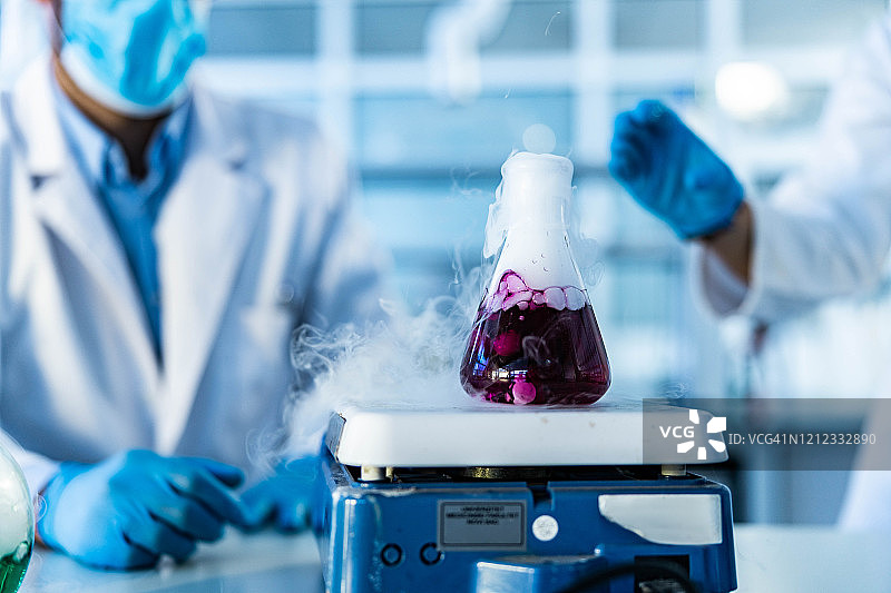 实验室内烧杯中用磁力搅拌器搅拌的紫色液体图片素材