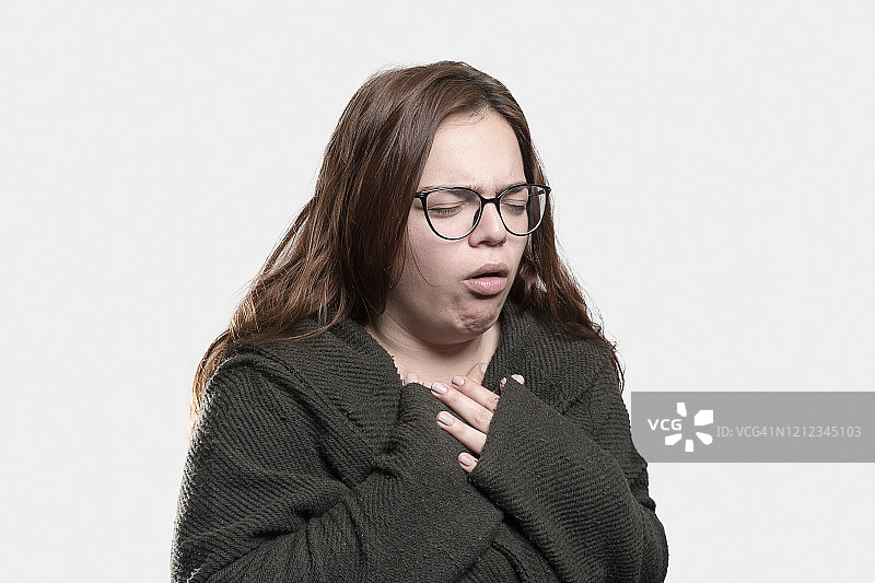 灰色背景上咳嗽的年轻女子的肖像图片素材