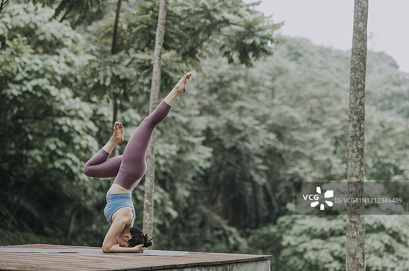 中国女性瑜伽教练示范单腿伸展蝎子式图片素材