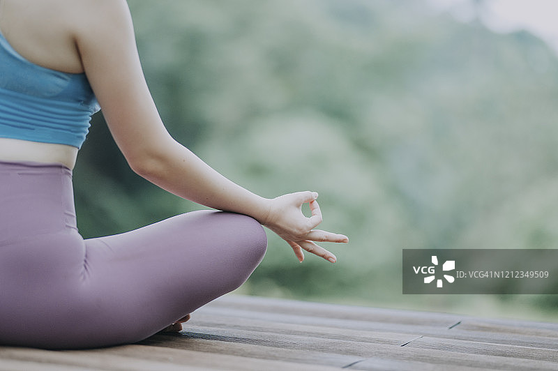 中国瑜伽教练在户外木台上冥想图片素材
