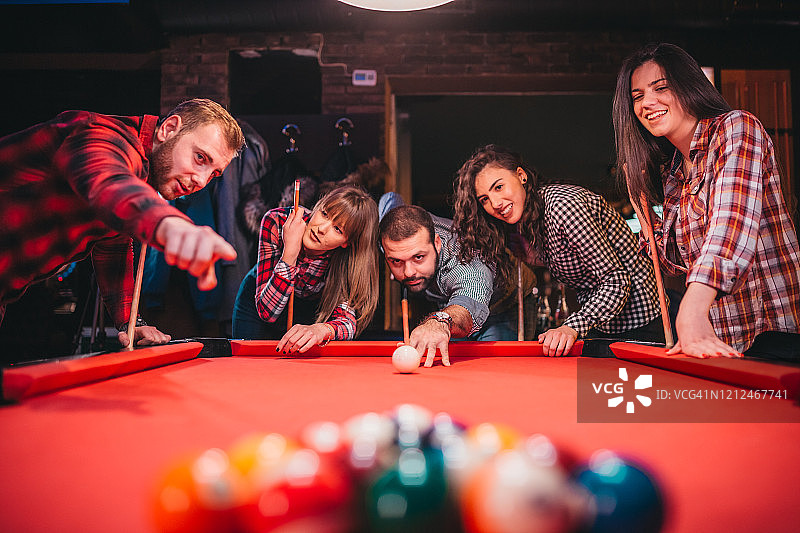 年轻快乐的人们在酒吧里玩台球图片素材