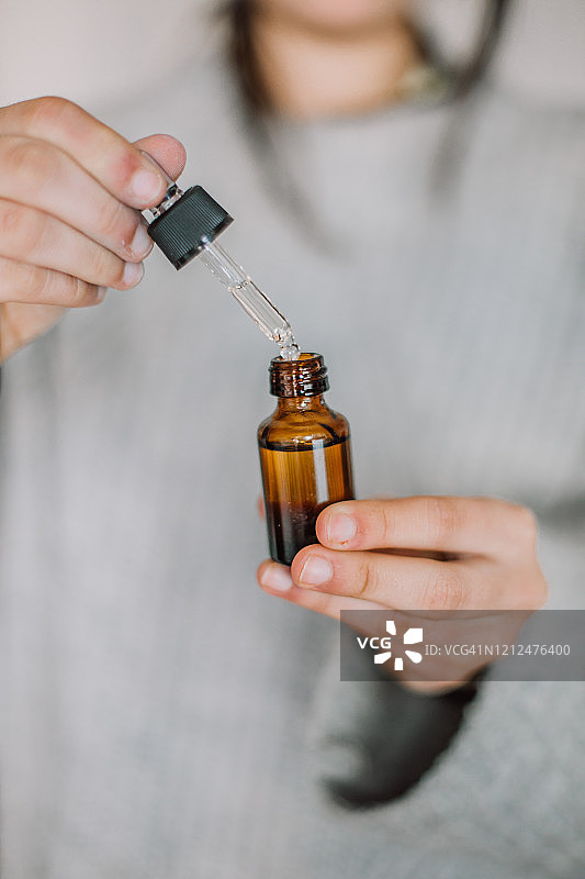 手持精油滴管的女人图片素材