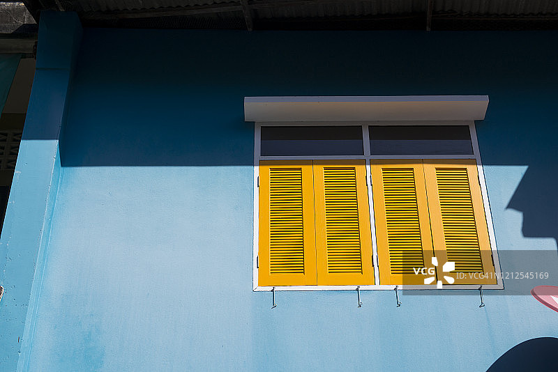 蓝色油漆建筑与黄色百叶窗图片素材