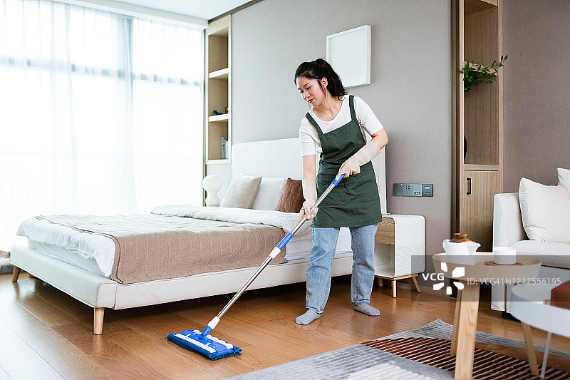 用拖把清洁房屋地板的女人图片素材