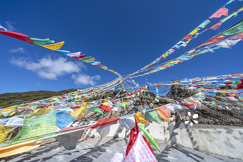 山顶上的藏族祈祷旗，沐浴在阳光下图片素材