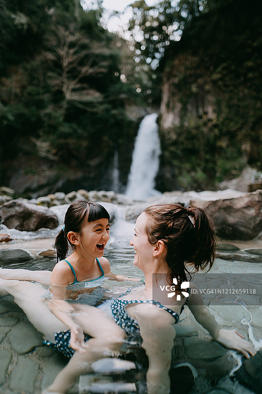 母亲和女儿在日本户外温泉浴池玩耍图片素材