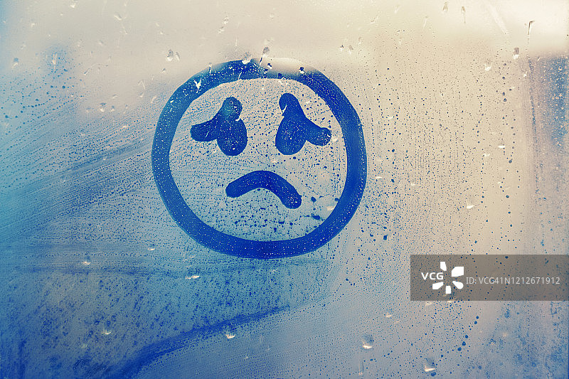 雾气玻璃窗上画的蓝色雨滴悲伤表情图片素材