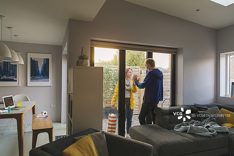 妻子给在家自我隔离的丈夫送物品图片素材