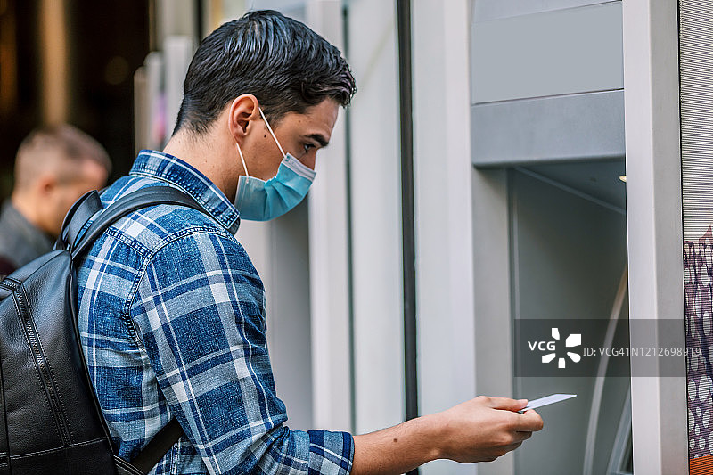 男人在ATM机上用信用卡取款图片素材