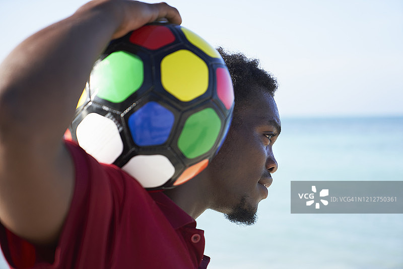 青年男子抱着彩色足球图片素材