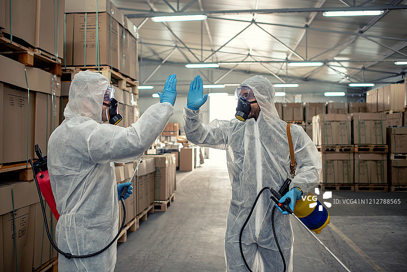 仓库中用喷雾器喷洒杀虫剂的害虫防治人员图片素材