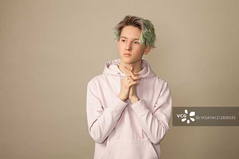 米色背景下的绿发少年棚拍写真图片素材