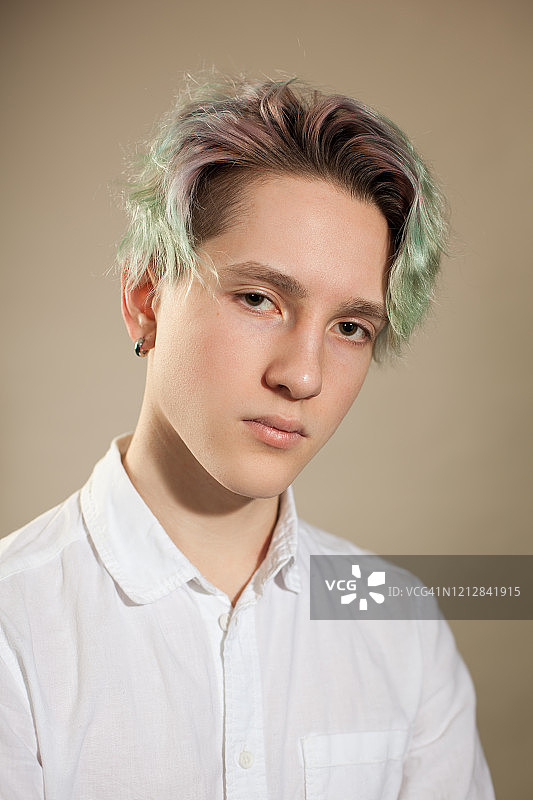 米色背景下的绿发少年棚拍写真图片素材