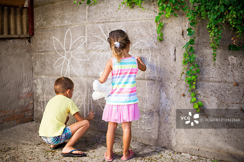快乐的小朋友们在墙上绘画，玩得很开心图片素材