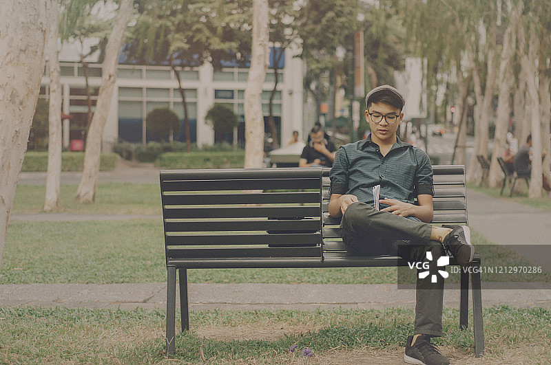在公园长椅上学习的青少年男生图片素材
