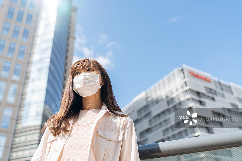 对没有冠状病毒的生活的希望概念。戴着防护面罩的女商人伸出双臂仰望图片素材