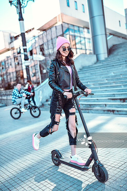 骑电动滑板车的女人和她的朋友们图片素材