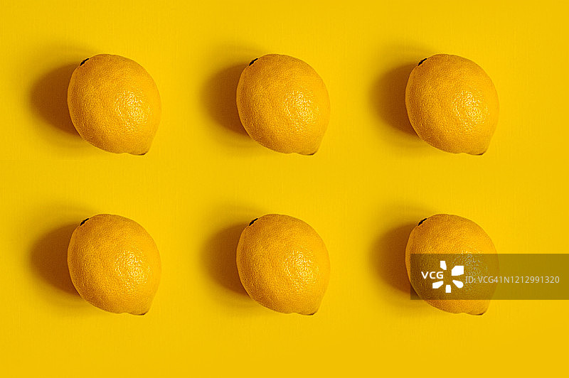 黄色背景上的柠檬图案，明亮多汁的柠檬维他命图片素材