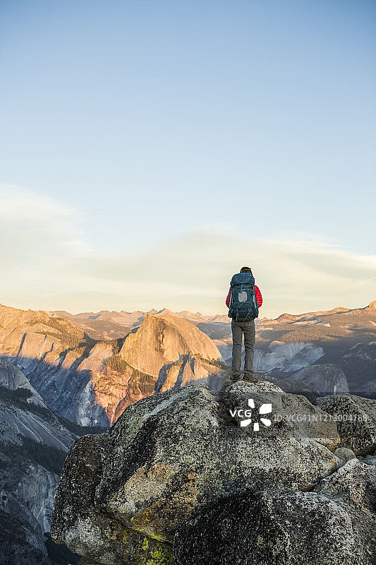 一名妇女在优胜美地山谷上方的山脊上徒步，远处是半圆顶图片素材