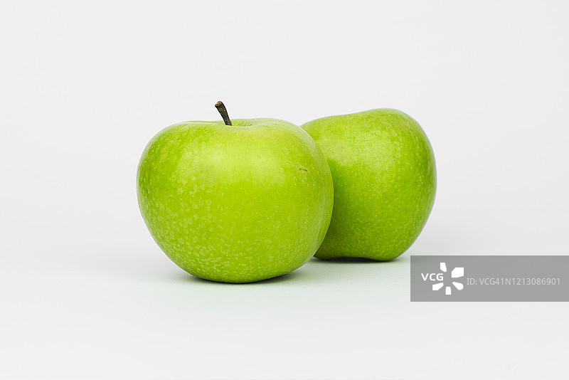 摄影棚中两个青苹果的特写图片素材