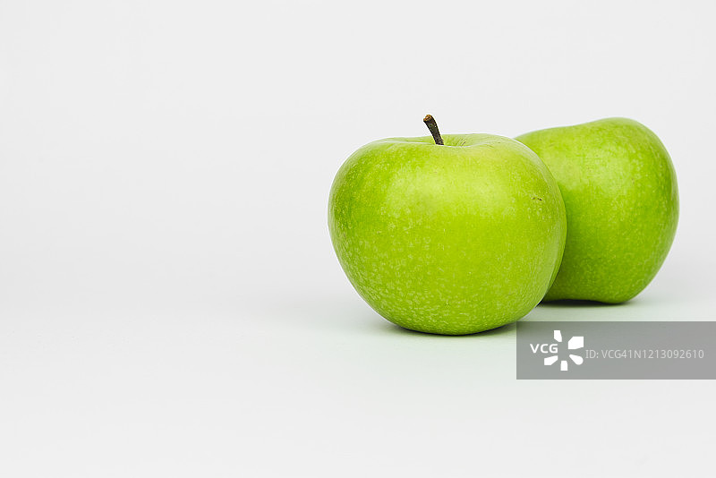 摄影棚中两个青苹果的特写图片素材