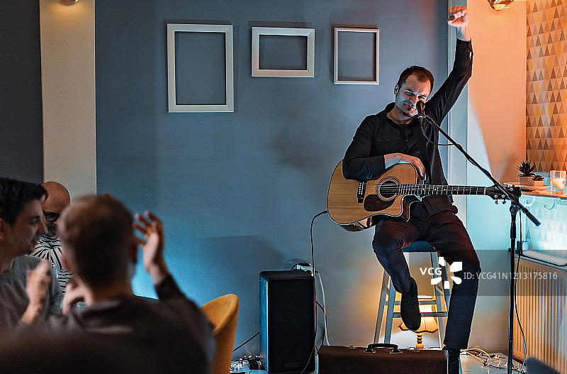 男子在舞台上弹吉他唱歌图片素材