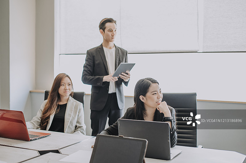 一群白领在商务会议中听取高层管理人员的报告图片素材